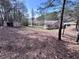 Expansive backyard with mature trees, storage shed, and a peek at neighboring houses at 5947 Rock Rd, Union City, GA 30291