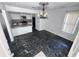 Open layout kitchen and dining area with elegant chandelier and black marble tile floor at 5947 Rock Rd, Union City, GA 30291