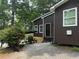 Charming exterior view of the lake house, featuring a front patio with a table, chairs, and a well-maintained yard at 7 Yachting Way, Acworth, GA 30102