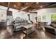 Open concept living room with exposed wood beams, leather sofa, kitchen and dining areas at 7 Yachting Way, Acworth, GA 30102