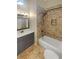 Nicely remodeled bathroom with brick-style accent wall, dark vanity, and tub at 2864 Sudbury Ct, Marietta, GA 30062