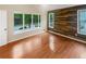 Bright bedroom featuring hardwood floors, wood accent wall, and a large bay window showcasing a serene outdoor view at 2864 Sudbury Ct, Marietta, GA 30062