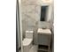 Contemporary bathroom features marble wall tiles, a gray vanity, and a sleek toilet at 1433 Woodland Sw Ter, Atlanta, GA 30311