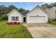 Charming single-Gathering home with a well-maintained lawn, blooming flowers, and an attached two-car garage at 402 Lafayette St, Dallas, GA 30157