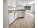 Bright kitchen features white cabinetry, tile floors, and a view of the breakfast nook for relaxed dining at 402 Lafayette St, Dallas, GA 30157