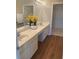 Bathroom featuring double sinks, light wood cabinets, and a view of a walk-in closet at 6133 Malloway Ct, Cumming, GA 30041