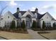 A grand exterior view of a home with symmetrical windows, a grand entrance, and lovely landscaping at 6133 Malloway Ct, Cumming, GA 30041