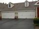Two-car garage doors with white trim, paired with well maintained paved driveway at 6133 Malloway Ct, Cumming, GA 30041