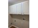 Laundry room with white cabinets for storage and utility connections at 6133 Malloway Ct, Cumming, GA 30041