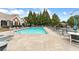 Outdoor pool with lounge chairs, tables, and lush greenery in a fenced area at 6133 Malloway Ct, Cumming, GA 30041