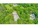 Aerial view featuring the horse arena, house, and barn nestled among lush, mature trees at 2585 Gelding Ne Ct, Marietta, GA 30062