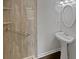 A charming bathroom featuring a walk-in shower with grab bars and a pedestal sink with an oval mirror at 806 Brighton Pt, Atlanta, GA 30328
