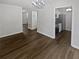 Living room with modern wood floors and contemporary chandelier, complemented by fresh, white-painted walls at 806 Brighton Pt, Atlanta, GA 30328