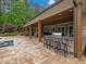 Outdoor kitchen with built-in grill, bar seating, and stone accents at 5759 Austin Garner Rd, Sugar Hill, GA 30518