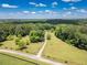 Scenic aerial view of a lush, tree-lined property with an inviting driveway under a bright, cloudy sky at 500 Cochran Rd, Covington, GA 30014