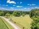 An aerial view of a sprawling property with a long driveway, expansive lawn, and bordered by lush trees at 500 Cochran Rd, Covington, GA 30014