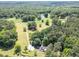 Picturesque aerial view of a property featuring a long driveway leading to a home bordered by verdant trees and a pond at 500 Cochran Rd, Covington, GA 30014