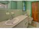A bathroom with a mint-green paint scheme, featuring a white porcelain sink and tiled shower and floors at 500 Cochran Rd, Covington, GA 30014