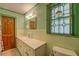 Bright bathroom with marble countertop, custom window, and green tiling at 500 Cochran Rd, Covington, GA 30014