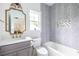 Stylish bathroom featuring a tiled shower-tub, hexagonal floor tiles, a gray vanity, and gold accents at 63 Holly Nw Rd, Atlanta, GA 30314