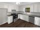 Modern kitchen with white cabinets, subway tile backsplash, stainless steel appliances, and dark hardwood floors at 3213 Cedar Bluff Ne Dr, Marietta, GA 30062