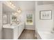 Bright bathroom with a double sink vanity, large mirror and picture window providing plenty of natural light at 565 Abbott Se Ct, Atlanta, GA 30354