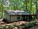 Back exterior view of home with neutral siding, enclosed porch, surrounded by mature trees at 5432 Post Road Pass, Stone Mountain, GA 30088