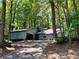 Ranch home with gray siding and a long driveway, nestled among lush trees at 5432 Post Road Pass, Stone Mountain, GA 30088