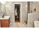 Elegant bathroom featuring marble style tiles, a modern sink and a view into a walk-in closet at 2105 Bentbrooke Trl, Lawrenceville, GA 30043