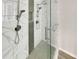 Modern bathroom shower featuring marble tile walls, a rainfall shower head, and a glass door enclosure at 6941 Gallant Se Cir # 10, Mableton, GA 30126