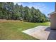 Large grassy backyard surrounded by tall trees, with a concrete patio at 2036 Broadmoor Way, Fairburn, GA 30213