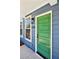 A vibrant green front door of a modern new construction townhome with blue siding at 1095 Tucker Ave # 106, Atlanta, GA 30310