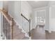 Bright foyer features a staircase with wood railing and iron spindles, leading to an open floor plan at 6045 Spring Way, Stonecrest, GA 30038