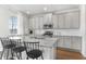 Modern kitchen features gray cabinets, granite countertops, stainless steel appliances, and breakfast bar at 6045 Spring Way, Stonecrest, GA 30038