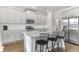 Bright kitchen with stainless steel refrigerator, granite island with barstool seating, and wood flooring at 6045 Spring Way, Stonecrest, GA 30038