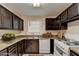 Kitchen featuring dark cabinets, marbled countertops, and white appliances at 102 Gettysburg Pl, Sandy Springs, GA 30350