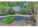 Community tennis court surrounded by a chain link fence and mature trees at 102 Gettysburg Pl, Sandy Springs, GA 30350