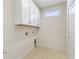 Clean laundry room featuring white cabinetry, neutral walls, and room for side by side units at 5245 Maggie Mae Ln, Cumming, GA 30028