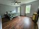 Spacious bedroom with a green and white comforter, hardwood floors, and large windows at 4503 Balmoral Nw Rd, Kennesaw, GA 30144