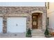 Elegant stone facade with arched doorway and white garage door creates a welcoming entrance at 220 Alcovy Ter, Alpharetta, GA 30009