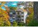 Multi-level rear view of a modern home featuring balconies and surrounded by lush foliage at 220 Alcovy Ter, Alpharetta, GA 30009