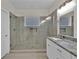 Bright bathroom featuring single sink vanity with granite countertops and a spacious tiled shower at 250 Stonecreek Pkwy, Covington, GA 30016