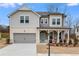 Charming two-story home featuring a welcoming front porch and a gray two-car garage at 5060 Trescott Path, Cumming, GA 30028