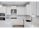 Modern kitchen with white cabinets, quartz countertops, and stainless steel appliances at 5060 Trescott Path, Cumming, GA 30028