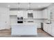 Modern kitchen with white cabinets, quartz countertops, and stainless steel appliances at 5060 Trescott Path, Cumming, GA 30028