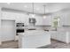 Modern kitchen with white cabinets, quartz countertops, and stainless steel appliances at 5060 Trescott Path, Cumming, GA 30028