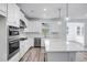 Modern kitchen with white cabinets, quartz countertops, and stainless steel appliances at 5060 Trescott Path, Cumming, GA 30028