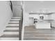 Modern staircase with metal railings leading to an open-concept kitchen at 5060 Trescott Path, Cumming, GA 30028