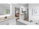 Bright, luxurious bathroom featuring dual vanities, a soaking tub, and elegant design elements at 3378 Pepperpike Ct, Loganville, GA 30052