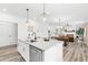 Bright kitchen features a center island, quartz countertops, and an open view to the dining and living area at 3378 Pepperpike Ct, Loganville, GA 30052